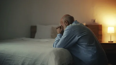 Exame de consciência noturno: roteiro diário para pedir perdão antes de dormir 8 pessoa rezando à noite perto da cama luz suave