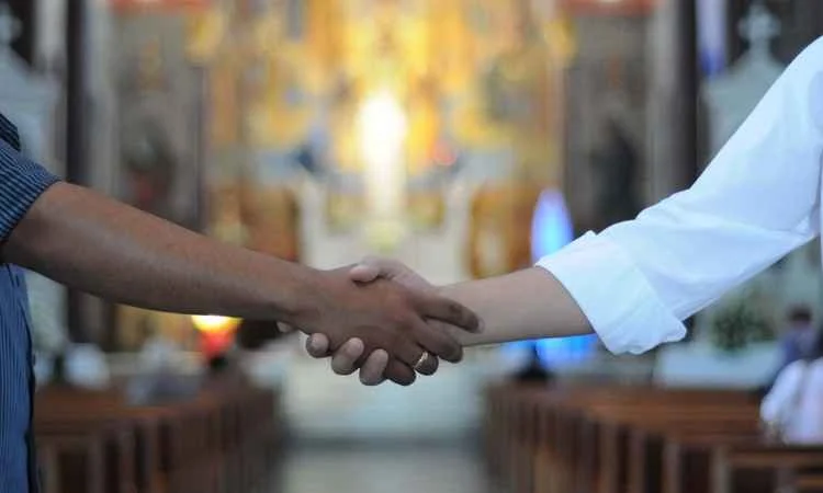 Ministério da Acolhida: como receber visitantes e organizar a saudação inicial 9 aperto de mão acolhedor entre fiéis na igreja