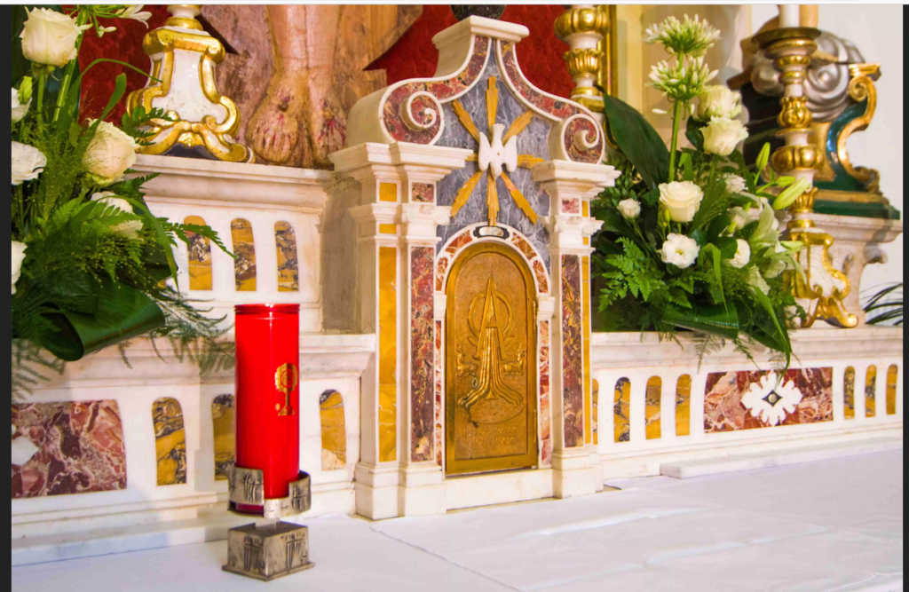 Como explicar a Presença Real de Jesus na Eucaristia para crianças de 7 anos 11 criança visitando o sacrário com a luz vermelha acesa em igreja tranquila