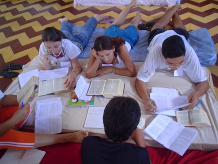 grupo de jovens em encontro de catequese com bíblia e círculo de conversa