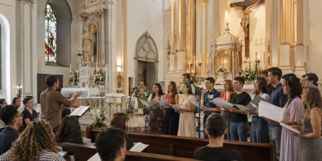 assembleia cantando durante missa com coral ao fundo, igreja católica