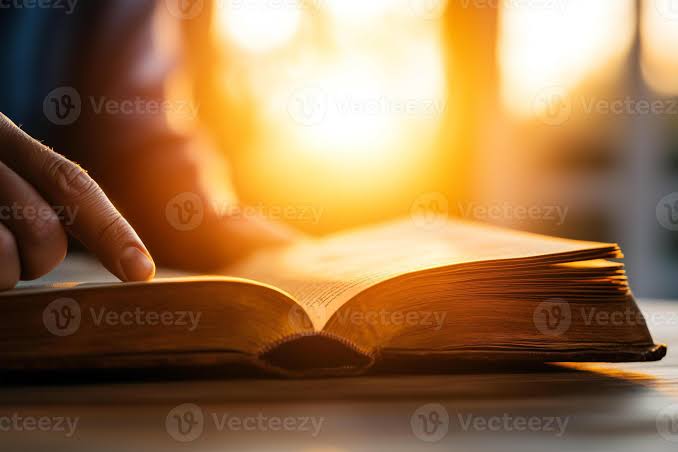 Oração vocal, meditação e contemplação: o que as distingue na tradição cristã 9 Pessoa lendo a Bíblia com um caderno, luz de mesa, ambiente recolhido