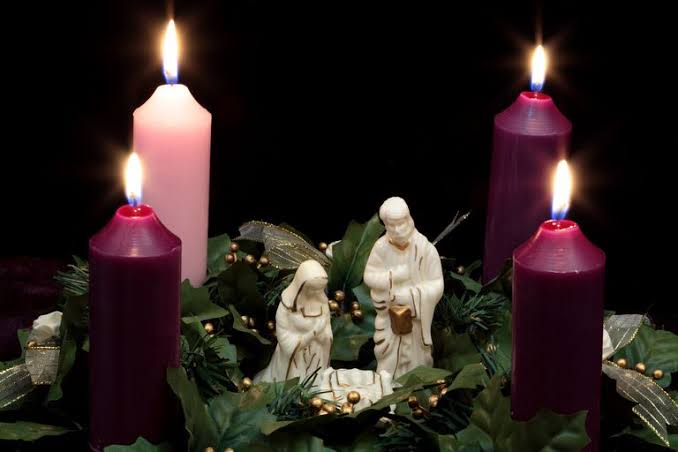 coroa do Advento com velas acesas em igreja católica
